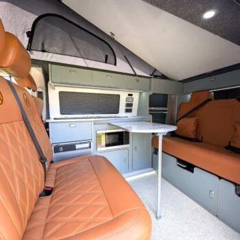 Complete interior shot featuring kitchen, bench, bed, and cabinetry in Spartan style