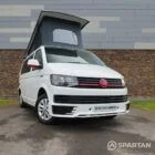 Front angle view of the VW T6 Candy White Campervan with alloy wheels and poptop down.