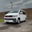 Front driver side view of VW T6 with poptop down.