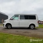 Passenger side view of VW T6 with poptop down.