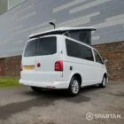 Rear driver side view of VW T6 with poptop up.