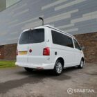 Rear driver side view of VW T6 with poptop down.
