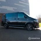 Close-up view of the VW T6 Highline campervan’s alloy wheels and high-gloss black finish.