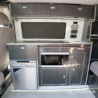 Campervan kitchen featuring Blizzard cabinetry and Carbon worktop