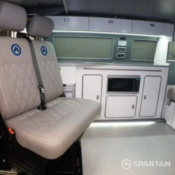 Dusk grey SPARTAN bench seat with precision blue stitching, shown swiveled forward