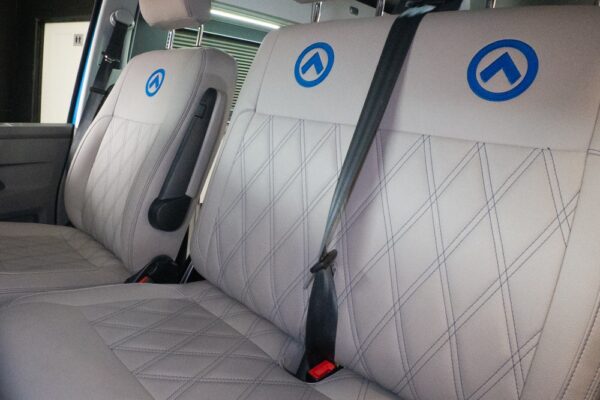 Dusk grey SPARTAN bench seat with precision blue stitching, shown swivelled forward