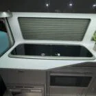 Two-ring gas hob inside Spartan Campers VW T6 campervan, built into the kitchen worktop for easy meal prep on the go
