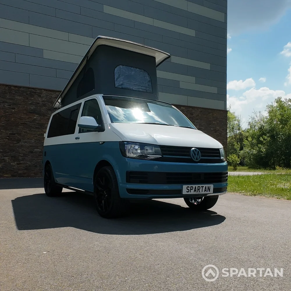 Driver side front view of Spartan Campers VW T6 campervan with poptop extended, perfect for spacious van life adventures