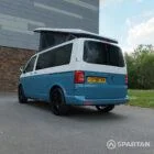 Spartan Campers VW Transporter T6 campervan with poptop extended, rear passenger side angle in Neptune blue and candy white