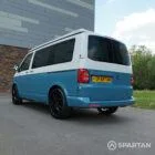 Spartan Campers VW Transporter T6 short wheelbase campervan in candy white and Neptune blue, rear passenger side view with poptop roof closed