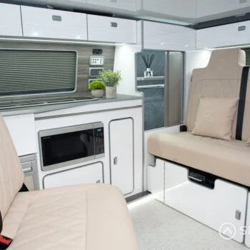 Spartan campervan kitchen featuring white units and silver birch worktops, expertly crafted for style and function