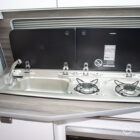 High-quality Spartan kitchen area with stainless steel sink and dual gas hob in a compact layout