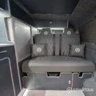 Rock and roll bed finished in pewter upholstery in VW T6.1 LWB campervan layout