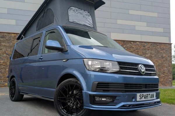 Spartan Campers VW T6 SWB campervan conversion in Acapulco Blue with pop-top roof raised, front driver quarter view