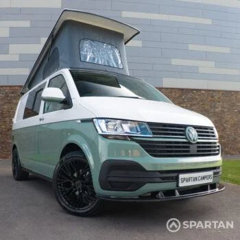 Front driver-side angle of sage green Spartan camper with poptop raised