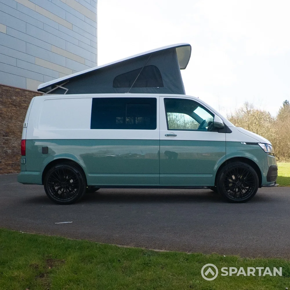 Driver side view of long wheelbase sage green VW T6.1 campervan with poptop open