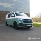 Front driver-side quarter of Spartan T6.1 camper in sage green with poptop down