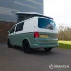 Rear passenger quarter view of sage green VW T6.1 LWB Spartan campervan with poptop raised