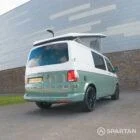 Rear driver quarter view of sage green Spartan VW T6.1 LWB camper with raised roof