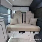 Rock and roll bed finished in ecru upholstery in VW T6.1 SWB campervan