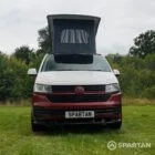 Head-on view of VW T6.1 Business Pack LWB campervan with pop-top roof up, Fortana Red and Candy White