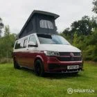 Front driver quarter of VW T6.1 Business Pack LWB campervan with roof up, Fortana Red and Candy White