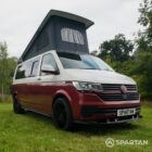 Front driver quarter of VW T6.1 Business Pack LWB campervan with roof up, Fortana Red and Candy White