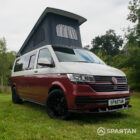 Front view of VW T6.1 Business Pack LWB campervan with wheels turned, Fortana Red and Candy White paint