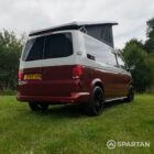 Rear driver quarter of VW T6.1 Business Pack LWB campervan with roof raised, Fortana Red and Candy White