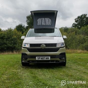 Head-on view of VW T6.1 Highline SWB campervan with pop-top roof up, Military Green and Candy White