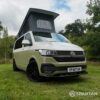Front view of VW T6.1 Highline SWB campervan with wheels turned, Military Green and Candy White paint