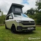 Front view of VW T6.1 Highline SWB campervan with wheels turned, Military Green and Candy White paint