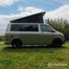 Driver side view of VW T6.1 Highline SWB campervan with pop-top up, Military Green and Candy White