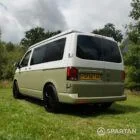 Rear passenger quarter view of VW T6.1 Highline SWB campervan, pop-top roof down, Military Green and Candy White