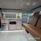 Interior kitchen view of VW T6.1 Highline SWB campervan with latte cabinets, Winchester oak detail, and winter flooring