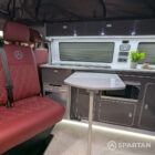 Close-up of VW T6.1 Business Pack LWB campervan kitchen showing integrated hob and white splashback