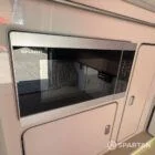 VW T6.1 Highline SWB campervan in white & military green, interior microwave view, champagne oak flooring, latte and winchester oak kitchen, toffee upholstery