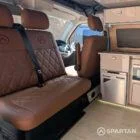 VW T6.1 Highline SWB campervan in white & military green, interior spartan swivel front bench seat view, champagne oak flooring, latte and winchester oak kitchen, toffee upholstery
