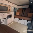 VW T6.1 Highline SWB campervan in white & military green, interior rock and roll bed view, champagne oak flooring, latte and winchester oak kitchen, toffee upholstery
