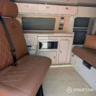 VW T6.1 Highline SWB campervan in white & military green, interior spartan swivel front bench seat view, champagne oak flooring, latte and winchester oak kitchen, toffee upholstery