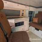 VW T6.1 Highline SWB campervan in white & military green, interior spartan swivel front bench seat view, champagne oak flooring, latte and winchester oak kitchen, toffee upholstery