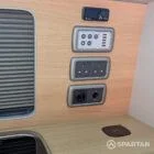 VW T6.1 Highline SWB campervan in white & military green, interior wireless charger control panel view, champagne oak flooring, latte and winchester oak kitchen, toffee upholstery