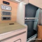 VW T6.1 Highline SWB campervan in white & military green, interior wardrobe view, champagne oak flooring, latte and winchester oak kitchen, toffee upholstery