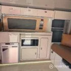 VW T6.1 Highline SWB campervan in white & military green, interior kitchen view, champagne oak flooring, latte and winchester oak kitchen, toffee upholstery