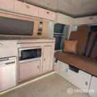 VW T6.1 Highline SWB campervan in white & military green, interior kitchen view, champagne oak flooring, latte and winchester oak kitchen, toffee upholstery