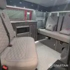 Internal images of a Spartan Campers VW campervan conversion. Including a rock and roll bed, microwave, sink, gas burners, fridge freezer, wireless fast charger, full length wardrobe and diesel night heater