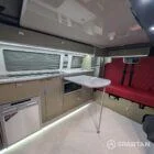 VW T6 LWB Deep Black campervan kitchen with olive green cabinetry, latte accents, and winter flooring