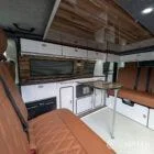 Interior kitchen view VW T6.1 Candy White & Copper Bronze campervan with Winter flooring, high gloss cabinetry and Nolche Marino worktop