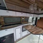 Interior kitchen view VW T6.1 Candy White & Copper Bronze campervan with Winter flooring, high gloss cabinetry and Nolche Marino worktop