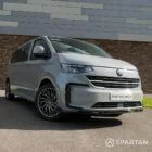VW T7 driver-side front quarter angle showing modern aerodynamic lines, Volkswagen badge and Spartan camper styling details